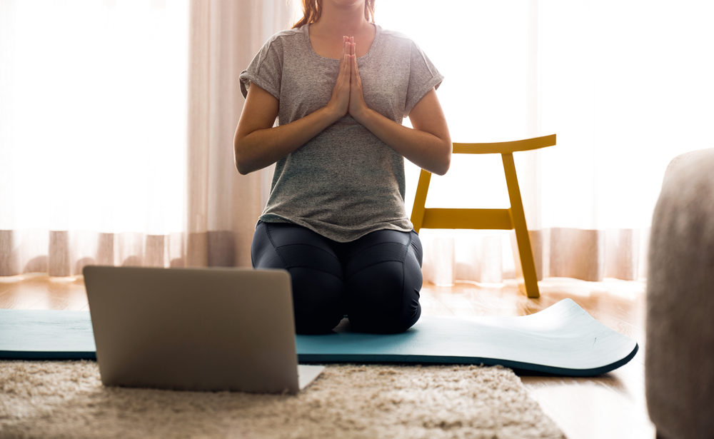 Shot of a woman doing yoga at home